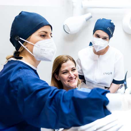 Dentists placing a bridge on implants